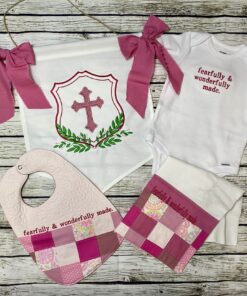 Pink handmade baby keepsake gift set with banner, bodysuit, bib, and burp cloth